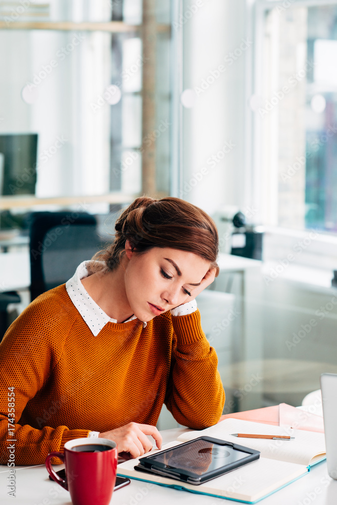 Businesswoman using digital tablet drinking coffee at work on break Businesswoman using digital tablet drinking coffee at work on break