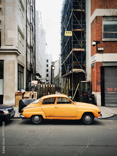 A yellow car parked in a cty photo