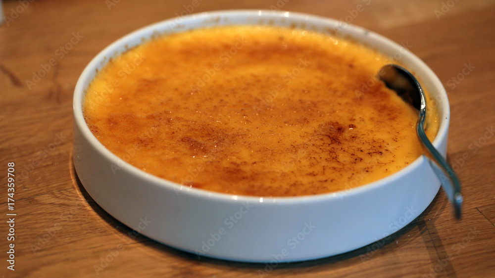 dessert detail - creme brulee in a white bowl with spoon dessert detail - creme brulee in a white bowl with spoon