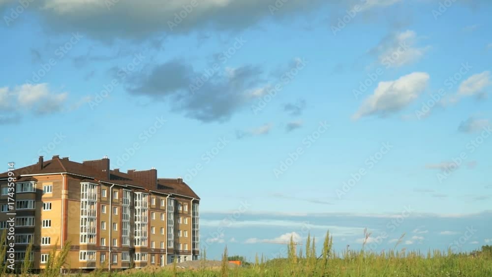 Timelapse of running summer clouds over new building - a brick five-story house in city Timelapse of running summer clouds over new building - a brick five-story house in city