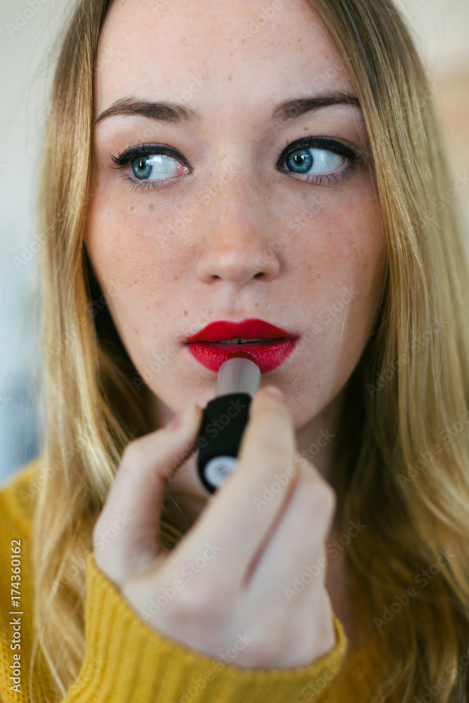 Beautiful woman applying red lipstick. Beautiful woman applying red lipstick.