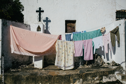 Laundry hanging out to dry surrounding a crucifix