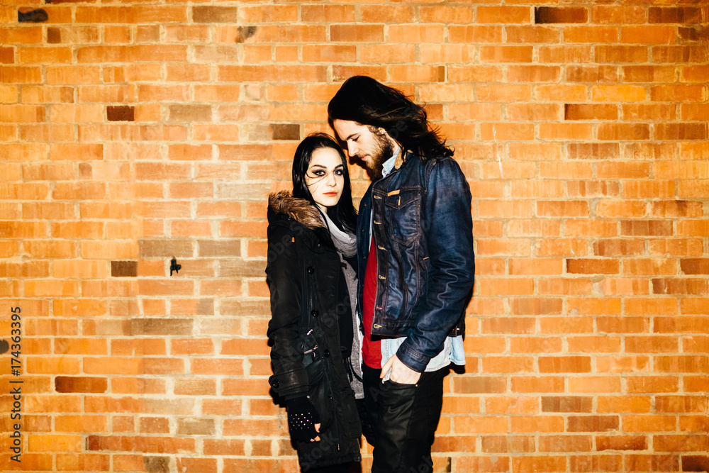 Young Couple Portrait in Front of a Brick Wall Young Couple Portrait in Front of a Brick Wall