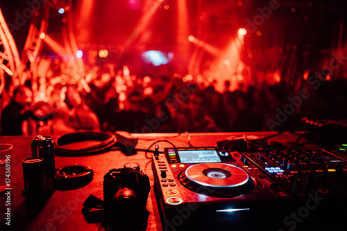 Dj equipment with crowd dancing in the background photo
