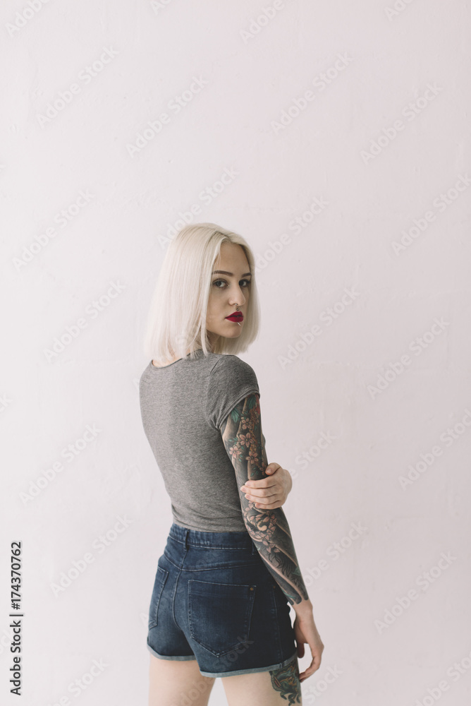 portrait of young blond woman with tattoos on the white background portrait of young blond woman with tattoos on the white background
