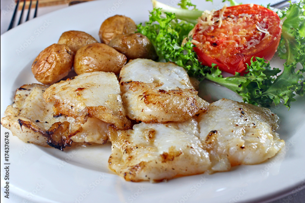 Grilled fish steak with vegetables, shallow focus