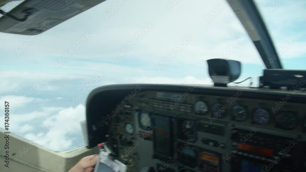 A still shot from an airplane's cockpit showing the beautiful sky and clouds from the outside and the dashboard of the plane inside the cockpit. A still shot from an airplane's cockpit showing the beautiful sky and clouds from the outside and the dashboard of the plane inside the cockpit.
