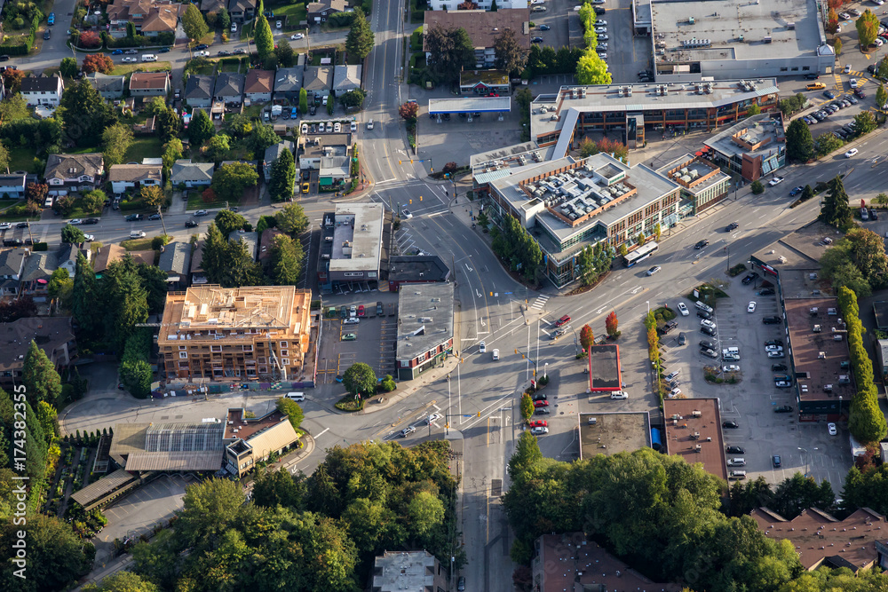 Fototapeta premium Aerial view on a street intersection in the vicinity of the shopping mall and residential neighborhood. Picture taken in North Vancouver, BC, Canada.