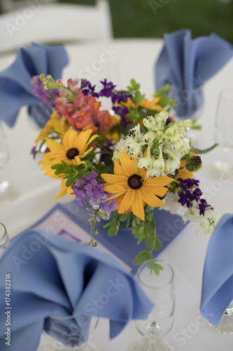 Fototapeta Naklejka Na Ścianę i Meble -  Wildflower Wedding Centerpieces with Black Eyed Susans, Snapdragons, and Delphinium on a Reception Table with White Tablecloth