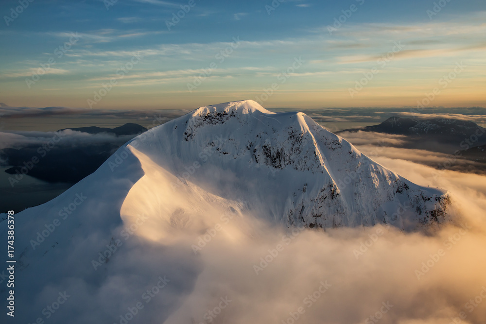 Aerial Landscape View Mt Wrottesley covered in snow during a beautiful sunset. Picture taken North of Vancouver near Howe Sound, BC, Canada.