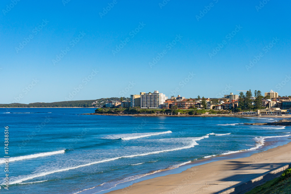 Ocean coastline with sand beach and waterfront property on the background