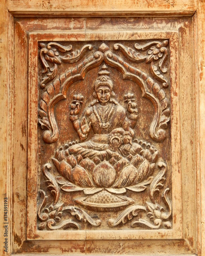 Wooden carving of Hindu Goddess Lakshmi on door of a temple
