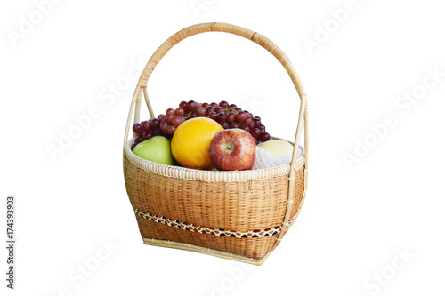 Bamboo basket put on a variety of fruit as orange, apple, grapes and pear.