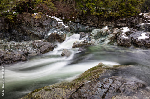 Nature view on the river flowing in between the rocks during winter. Picture taken near Tofino, Vancouver Island, British Columbia, Canada.