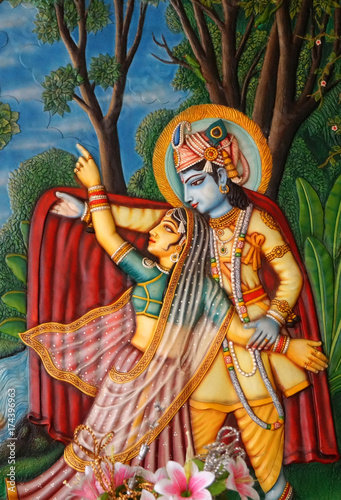 Wall art of Hindu god Sri Krishna and Radha playful in a garden in brindavan in a temple