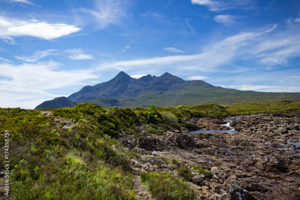 Mountain peaks of the Black Cuillins and Tir Nan Iolaire or the Land of Eagles with a drying riverbed and slight stream running through. Mountain peaks of the Black Cuillins and Tir Nan Iolaire or the Land of Eagles with a drying riverbed and slight stream running through.