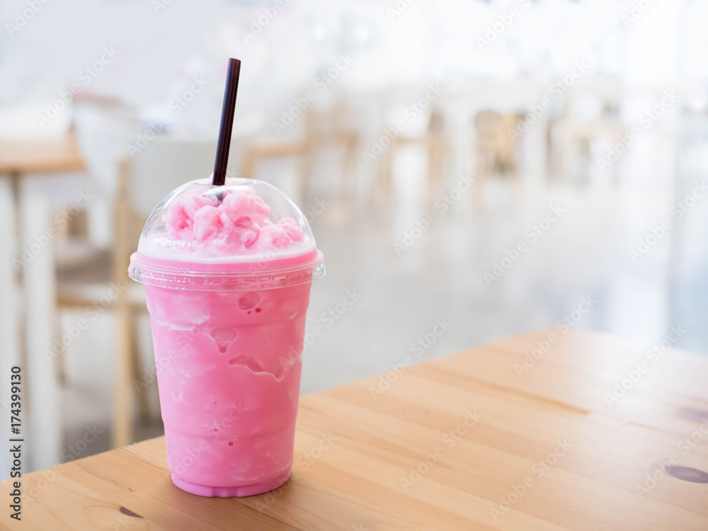 Plastic cups of milkshake on color wooden background Stock Photo