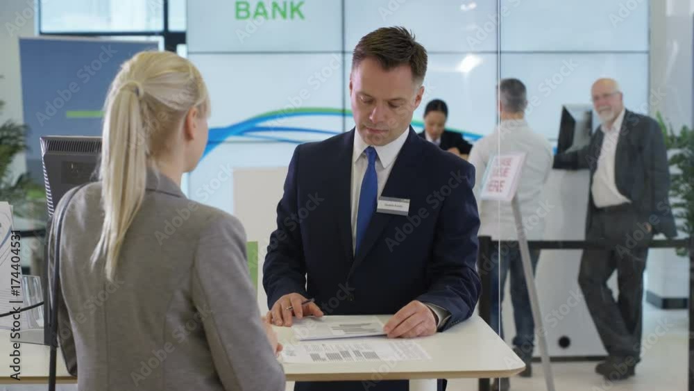  Bank with friendly adviser talking to customer, as seen from customer's pov