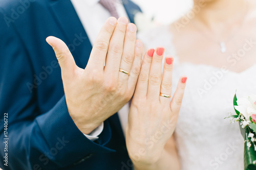 Hands of bride and groom with rings.