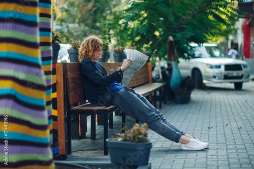  Red haired hipster man lying on bench reading newspaper © arthurhidden