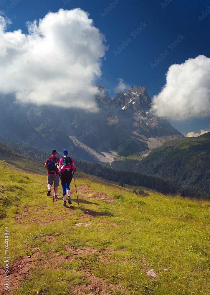 Couple of walking tourists in the mountains, Dolomites, Italy