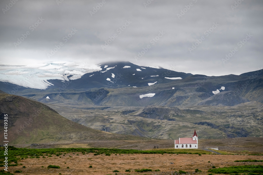 Obraz premium Scenic view of typical icelandic church in front of a snowy mountains.