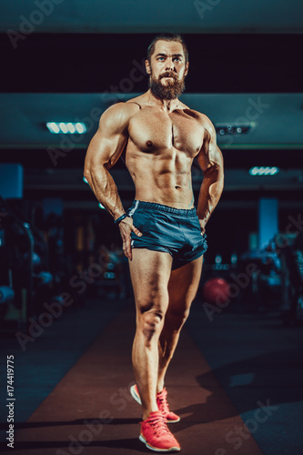 Obraz na płótnie Athlete muscular bearded bodybuilder man with naked torso posing in gym
