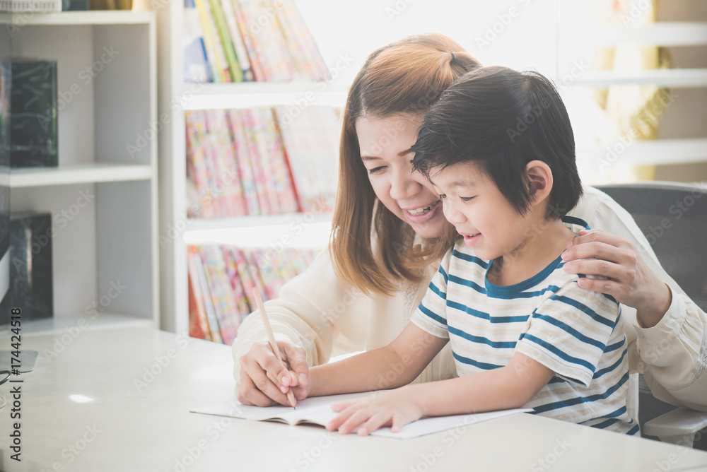 Asian mother helping her son doing homework