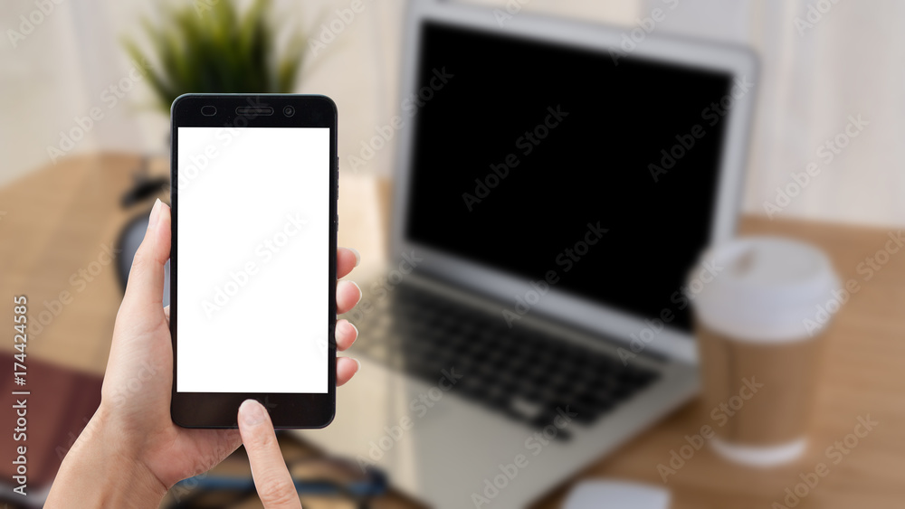 Asian woman hand holding smart phone on background workplace table.
