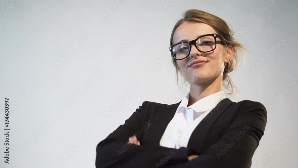 Ambitious young dark hair caucasian businesswoman, in a white blouse and a black jacket, is posing in the white background, isolated, slow motion Ambitious young dark hair caucasian businesswoman, in a white blouse and a black jacket, is posing in the white background, isolated, slow motion