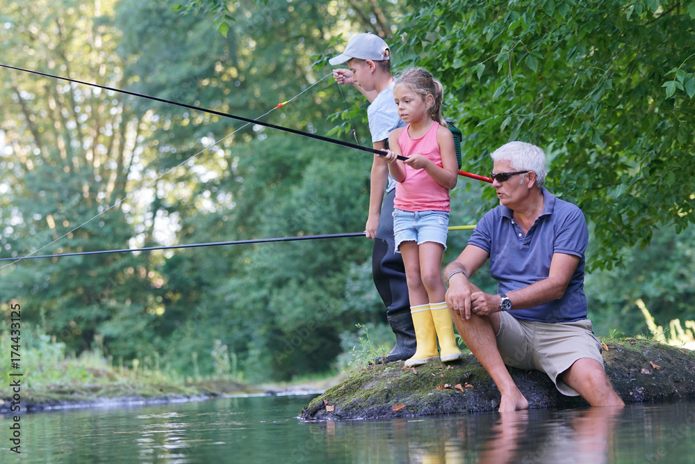 Dad teaching kids how to fish in river Dad teaching kids how to fish in river