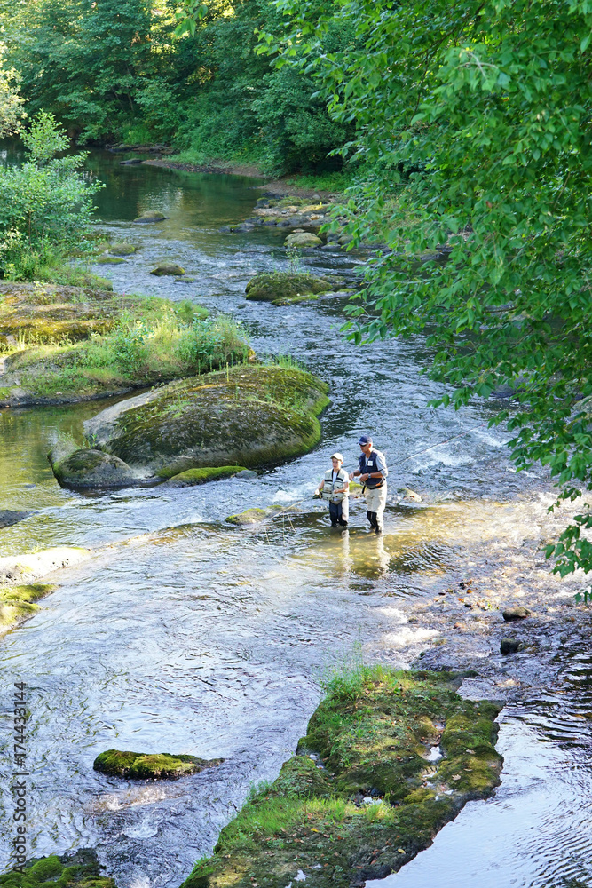 Obraz premium Aerial view of man with kid fly-fishing in river