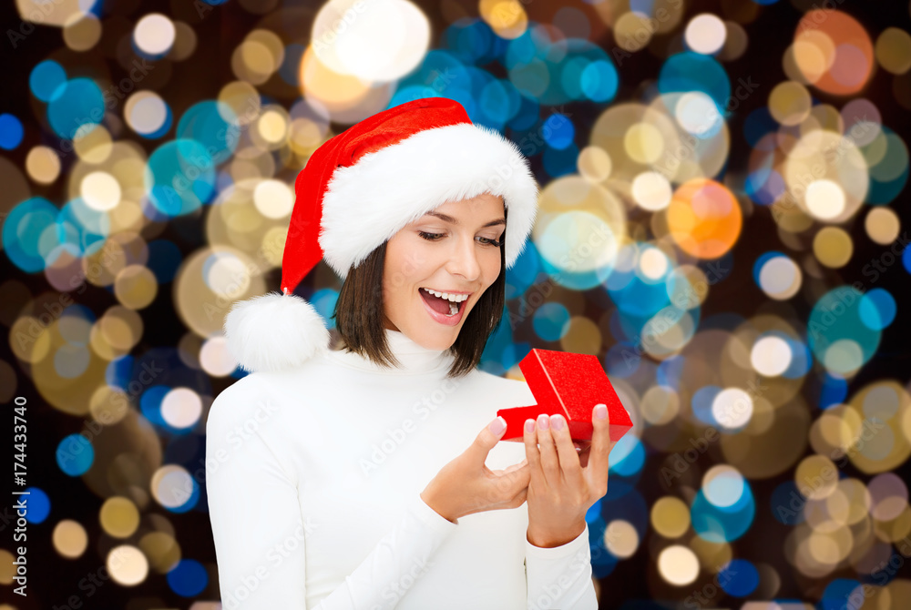happy woman in santa hat opening christmas gift happy woman in santa hat opening christmas gift