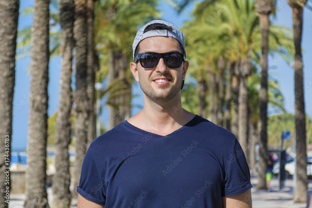 handsome man with sunglasses enjoy vacation on a tropical resort with green palms handsome man with sunglasses enjoy vacation on a tropical resort with green palms