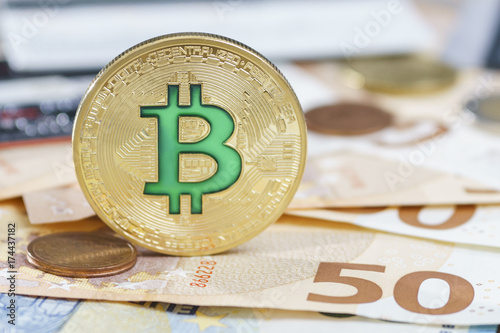 Cryptocurrency physical green bitcoin coin over the euro money. photo