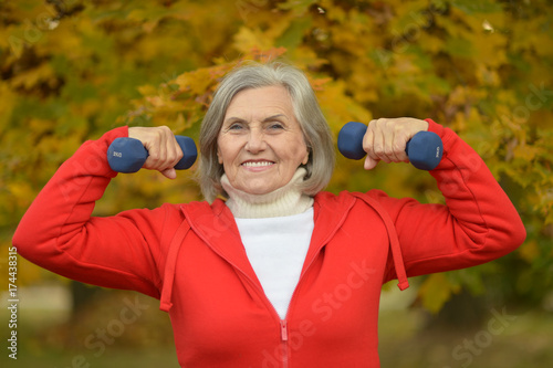 fit Senior woman exercising with dumbbells