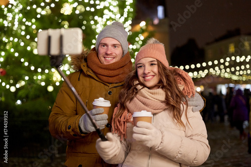couple with coffee taking selfie at christmas