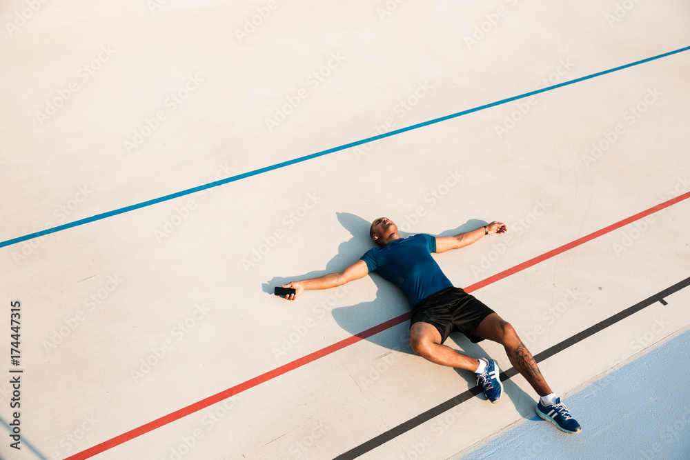 Obraz premium Top view portrait of an exhausted young african fitness man