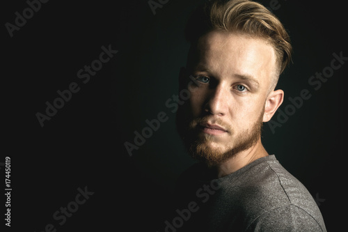 portrait of young man above black background