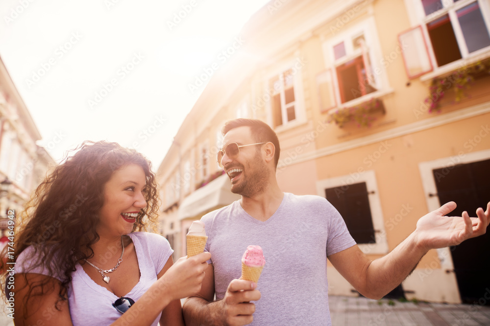 Young happy couple enjoying ice cream and summer in the city. Young happy couple enjoying ice cream and summer in the city.