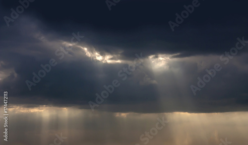 Dramatic atmosphere Panorama view of storm clouds background with ray of sunlight pass through.
