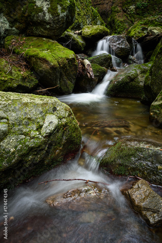 Waterfall and rocks covered with moss in the forest