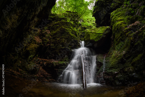 Waterfall and rocks covered with moss in the forest