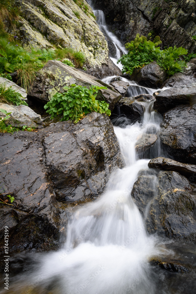 Waterfall and rocks covered with moss in the forest Waterfall and rocks covered with moss in the forest