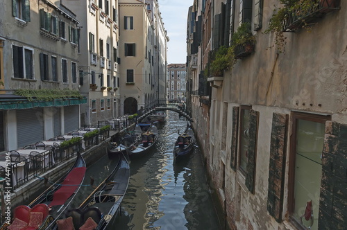 Traditional gondola ride in small canal at residential district of historical buildings and bridge, Venezia, Venice, Italy, Europe 
