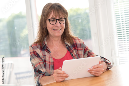 Mature woman using a tablet Free Download Mature woman using a tablet - GFXLoad