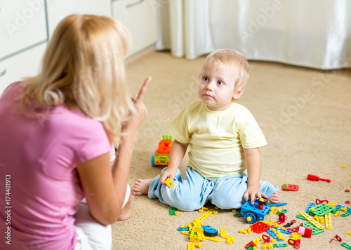 Mother scolding her little kid in jest at home