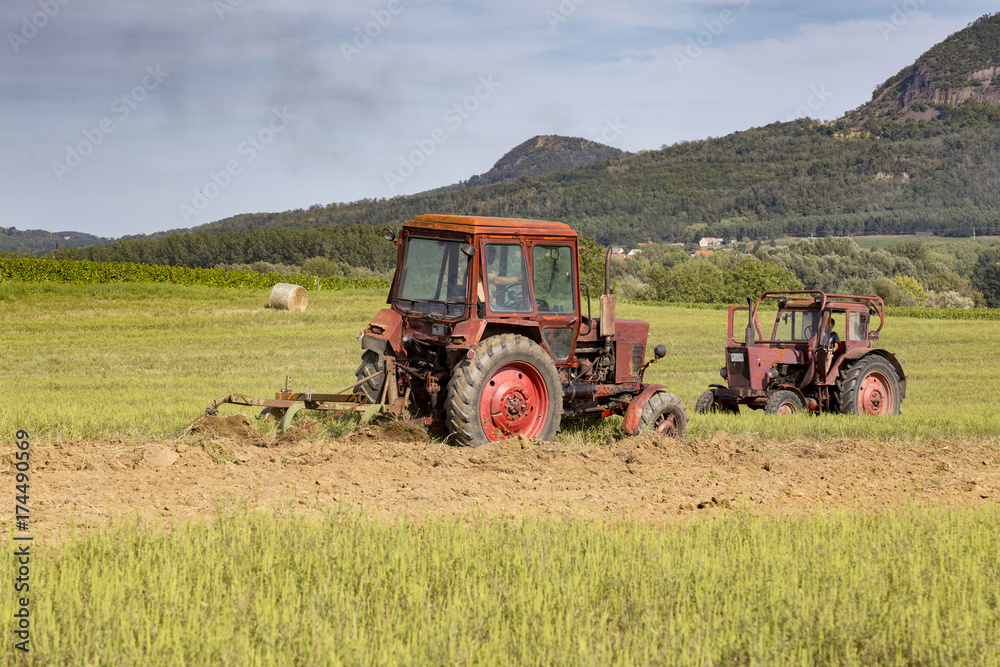 Obraz premium Old tractor working on the field