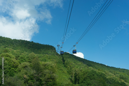 mountain landscape on background of blue cloudy sky and a view of the cable car