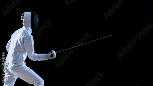 Side View of a Fully Equipped Skilled Fencer Training His Attack and Lunge with a Foil. Shot Isolated on Black Background.